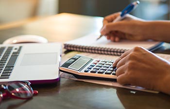 woman working with calculator business document and laptop computer notebook