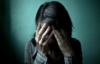 depressed woman covering face with hands
